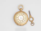 an image of a gold pocket watch with a key on a white surface