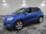 a blue chevrolet trax is parked in a large room