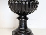 a black vase that is sitting on a white table