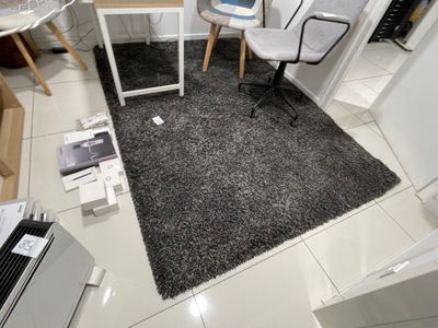 une pièce avec un bureau, une chaise, un ordinateur portable et d'autres objets posés par terre