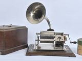 an old fashioned gramphone next to a box and a roll of toilet paper