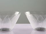 pair of clear glass vases sitting on top of a white table