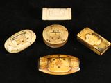 four pieces of carved ivory with designs on them sitting on a black surface