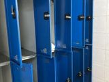 Plusieurs casiers bleus sont alignés les uns à côté des autres dans une salle de bains