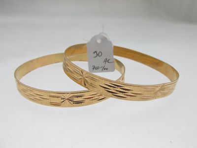 deux bracelets en or avec une étiquette de prix accrochée dessus