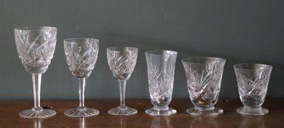 sept verres à vin alignés sur une table en bois