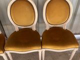 quatre chaises avec coussins de dossier rembourrés jaunes