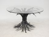 a round glass table with metal branches on top