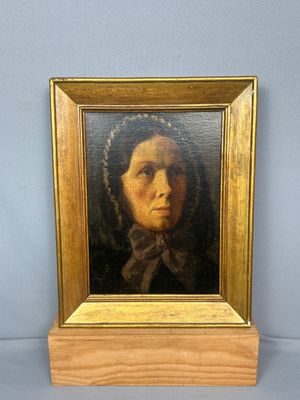 une peinture à l'huile représentant une femme portant un foulard, dans un cadre doré