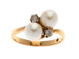 une bague en or ornée de deux perles et de diamants