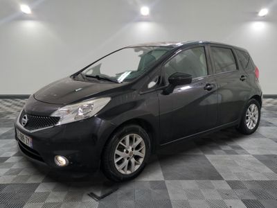 the black nissan versa is parked on a checkered tile floor