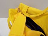 a yellow duffel bag with a smiley face on it
