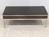 the coffee table has a black glass top and metal legs