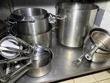 many pots and pans sitting on a stainless steel counter