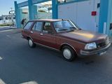 a brown car parked in front of a gas station
