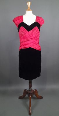 une robe noire et rose posée sur un présentoir pour mannequin