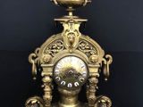 une horloge dorée posée sur une surface noire