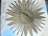 une horloge posée sur une table, à côté d'une feuille de papier