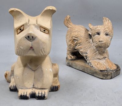 une paire de figurines de chiens en céramique, dont l'une est assise par terre