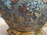 a large vase with flowers on it sitting on a table