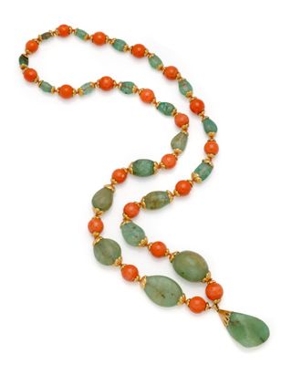 un gros plan sur un long collier composé de perles vertes et orange