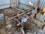 un vieux tracteur équipé d'une charrue, dans une grange