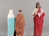 three figurines of jesus, mary and jesus on a gray background