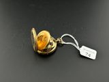 an image of a gold locke with a tag on a black surface