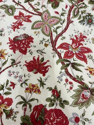 a red and green floral pattern on a white table cloth