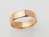 a gold wedding ring on a white background