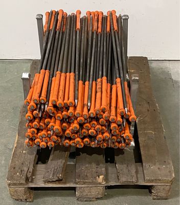 un tas de tiges de tuyaux orange et noires sur une palette