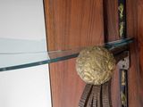 a glass shelf with a gold ball on it