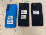 Trois modèles de téléphones Oppo de couleurs différentes sont posés sur une table.