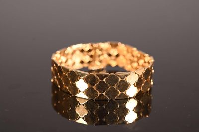 a close up of a gold bracelet on a black surface