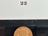 a close up of a gold coin on a black surface