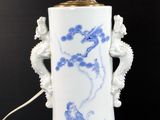 a blue and white vase with a light on it