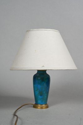 une lampe bleue avec un abat-jour blanc posée sur une table