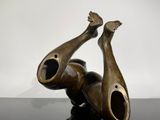 a bronze sculpture of a man laying on his back