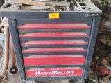 a red and black tool box sitting in a garage