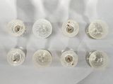 six clear glass cups on a table with a white background