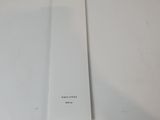 Quelqu'un tient un marque-page blanc sur une table blanche.