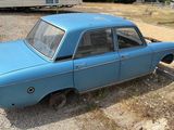 a blue car that is sitting in the dirt