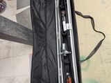 un étui à guitare posé par terre, avec une guitare à l'intérieur