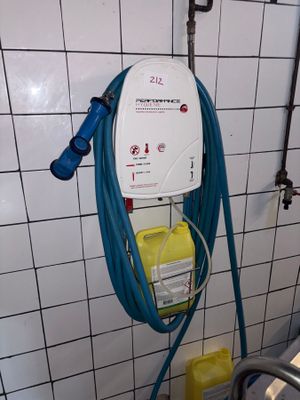 a blue hose attached to a wall in a bathroom