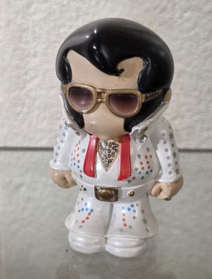 une petite figurine d'Elvis Presley portant des lunettes de soleil