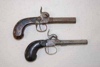 two old guns are sitting on a white surface next to each other