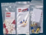 trois sachets de Lego posés sur une surface bleue