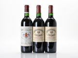 three bottles of wine are lined up on a white surface