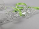 a glass bottle with a green ribbon and a glass bottle with a flower on it