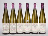 six bouteilles de vin sont alignées sur une surface blanche